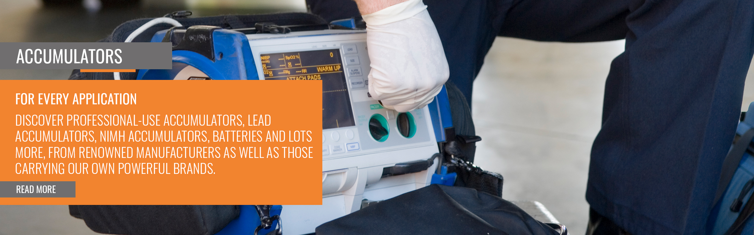 Personal sanitario especializado, con guantes blancos, maneja un desfibrilador portátil/monitor de pacientes. La pantalla muestra los valores de medición y los controles. La persona ajusta los botones y los mandos del dispositivo azul y blanco.