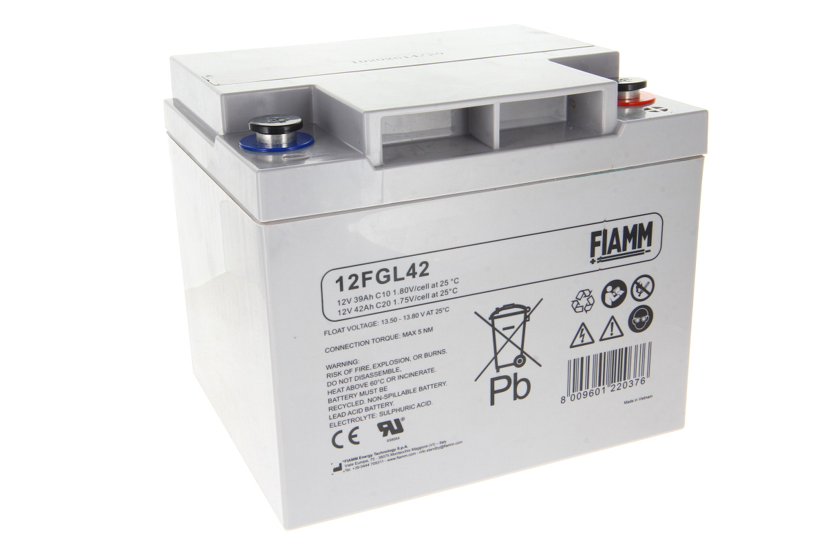 Batteria industriale FIAMM 12FGL42 grigio chiaro, forma parallelepipeda, su sfondo bianco. In alto due poli con cappucci rossi e blu. Sul fronte dati tecnici (12 V 39/42 Ah) e simboli riciclaggio, Pb e avvertenze.