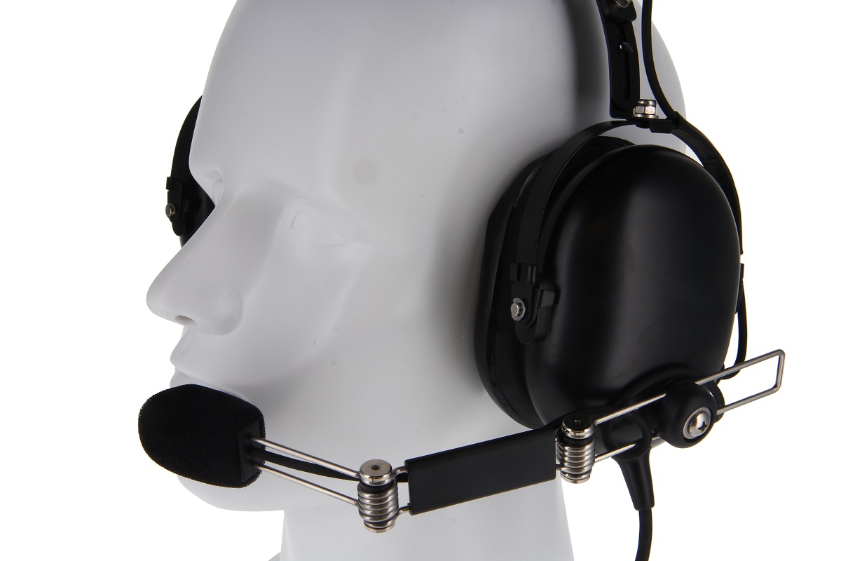 Svart CoPacks Headset GES-H07 med stora öronkåpor och flexibel framåtriktad mikrofonbom, med svart skumskydd. Robust headset på vitt mannekänghuvud med sidovy, perfekt för radiokommunikation.