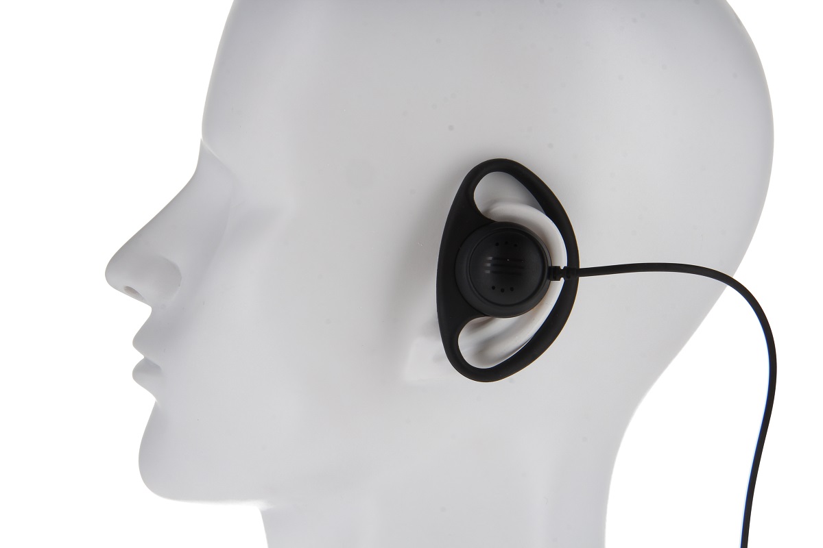 Un auricular negro con un gancho en forma de D está fijado a la oreja derecha de la cabeza de un maniquí blanco. Tiene un altavoz redondo con pequeños orificios y un cable negro fino que cuelga hacia abajo. Apto para un controlador.