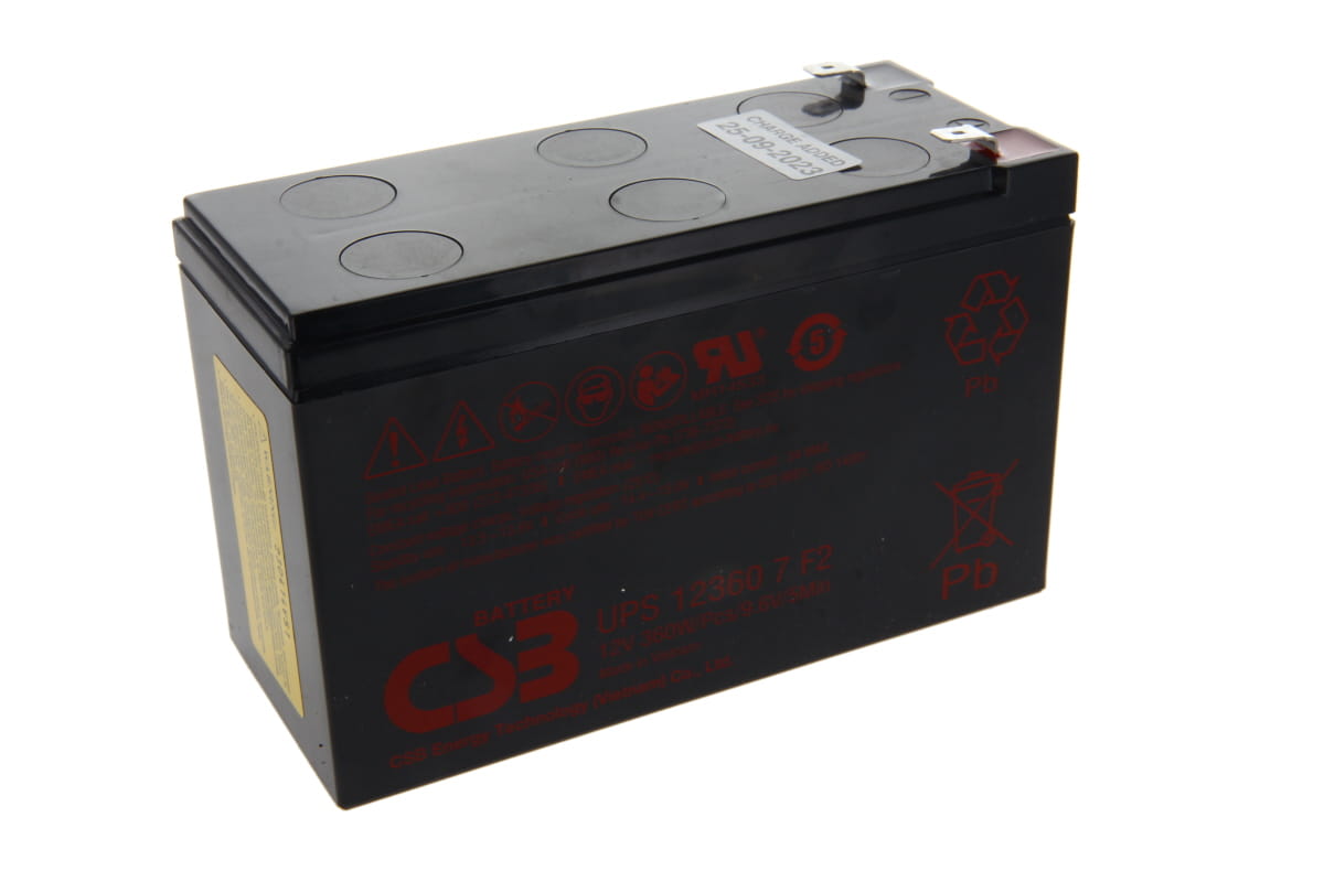 Batería de plomo CSB UPS123607F2, rectangular negra, vista superior en ángulo. Arriba, dos terminales Faston plateados. Laterales con advertencias rojas, logotipo CSB y modelo UPS 12360 7F2. Etiqueta blanca con fecha.