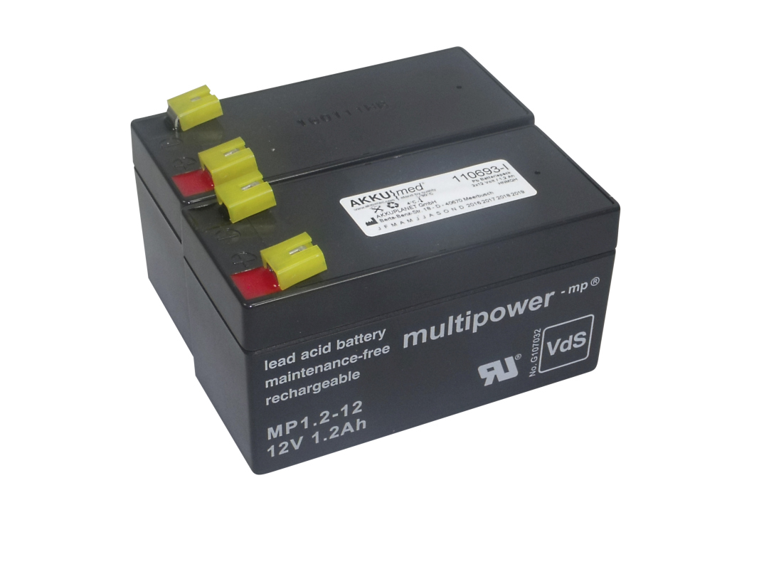 Two black lead-acid batteries, side by side and connected, with red/black terminals and yellow protective caps. Label: AKKUmed Multipower -mp®, maintenance-free, MP1.2-12, 12V 1.2Ah. For hospital beds.