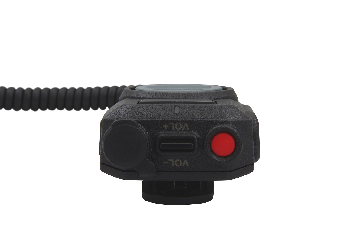 Robusto microfono con altoparlante GE-XM05 nero di CoPacks, vista frontale. Con regolatore di volume (+/−), pulsante rosso di emergenza, pulsante PTT frontale, presa protetta e cavo a spirale. La superficie strutturata sottolinea la struttura robusta.
