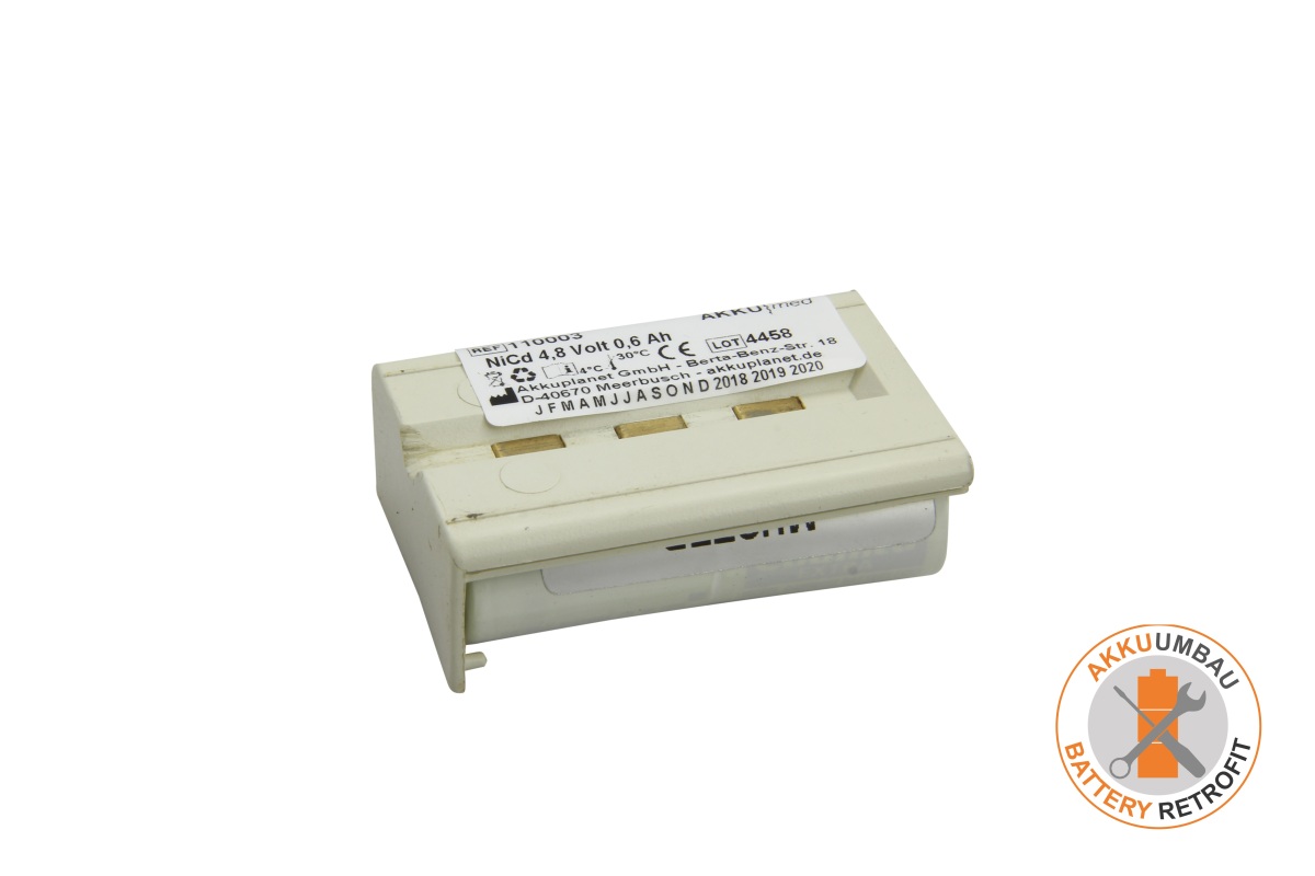 Bloque de batería NiCd compacto, de color beige, con etiqueta blanca: «AKKUMED », «NiCd 4,8 voltios 0,6 Ah» y «CE». Para tensiómetros Customed. Tres contactos dorados en la parte superior, con la parte inferior ligeramente saliente.