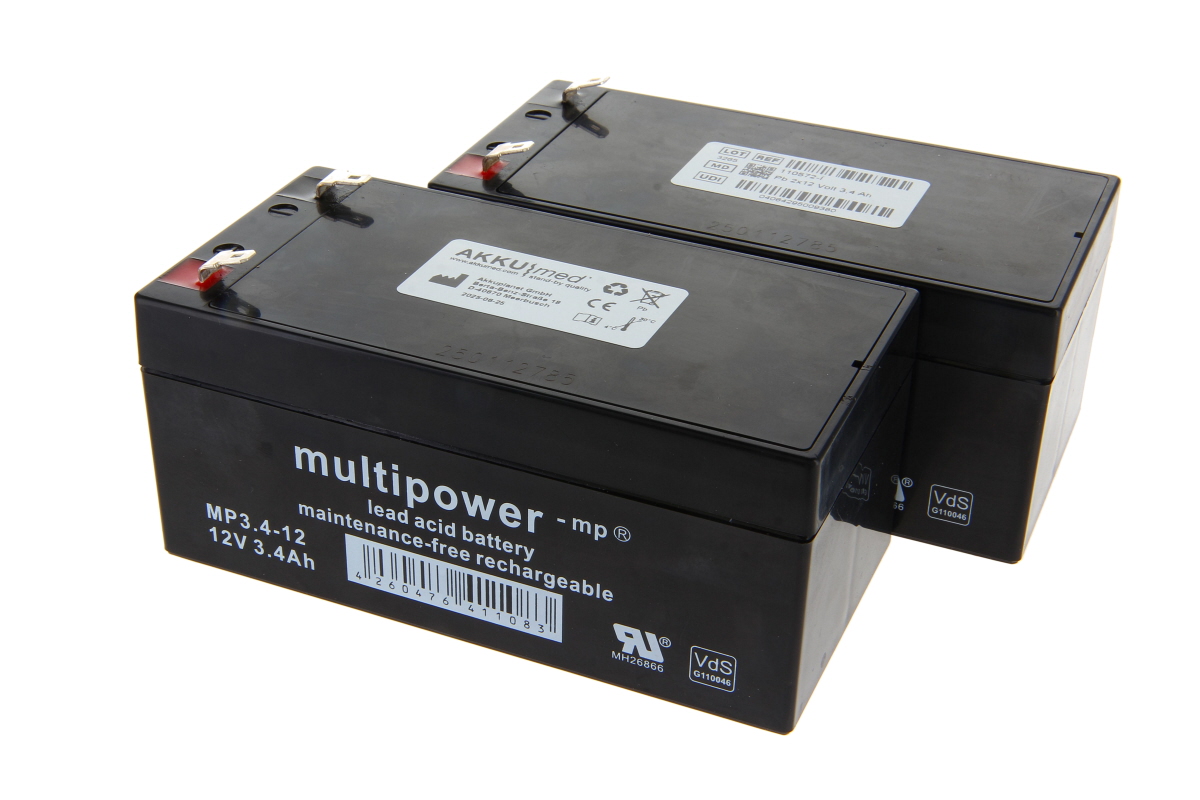 Två svarta, rektangulära blybatteriinsatser från AKKUmed till Völker batterilådor typ S961-2W. Varje batteri har silverplintar upptill med röda och svarta anslutningar. Märkning: AKKUmed, 12V 3,4Ah, underhållsfritt, uppladdningsbart.