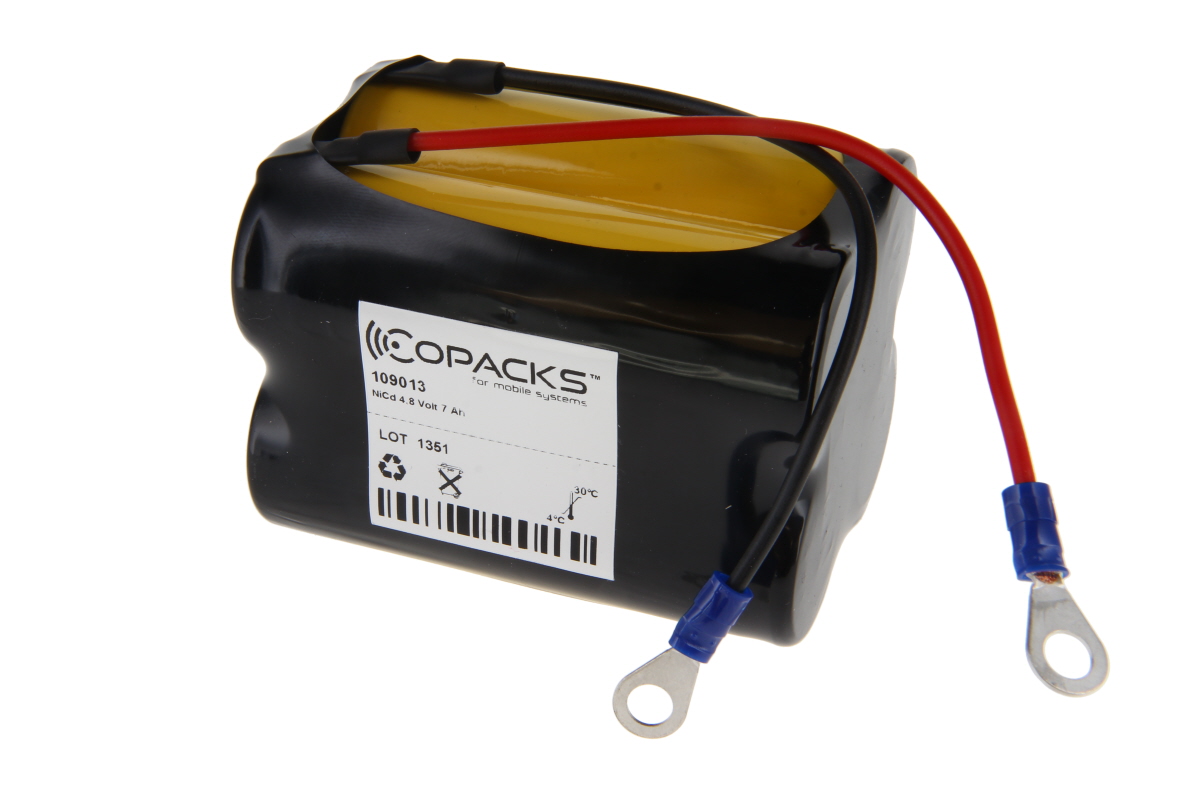 Svart CoPacks NiCd-batteripaket med gula celler synliga upptill och två anslutningskablar (röd/svart) med blå isolerade ringplintar. Märkt med: CoPacks, modell 109013, NiCd 4,8 V 7 Ah, återvinning. För CEAG handlampor.