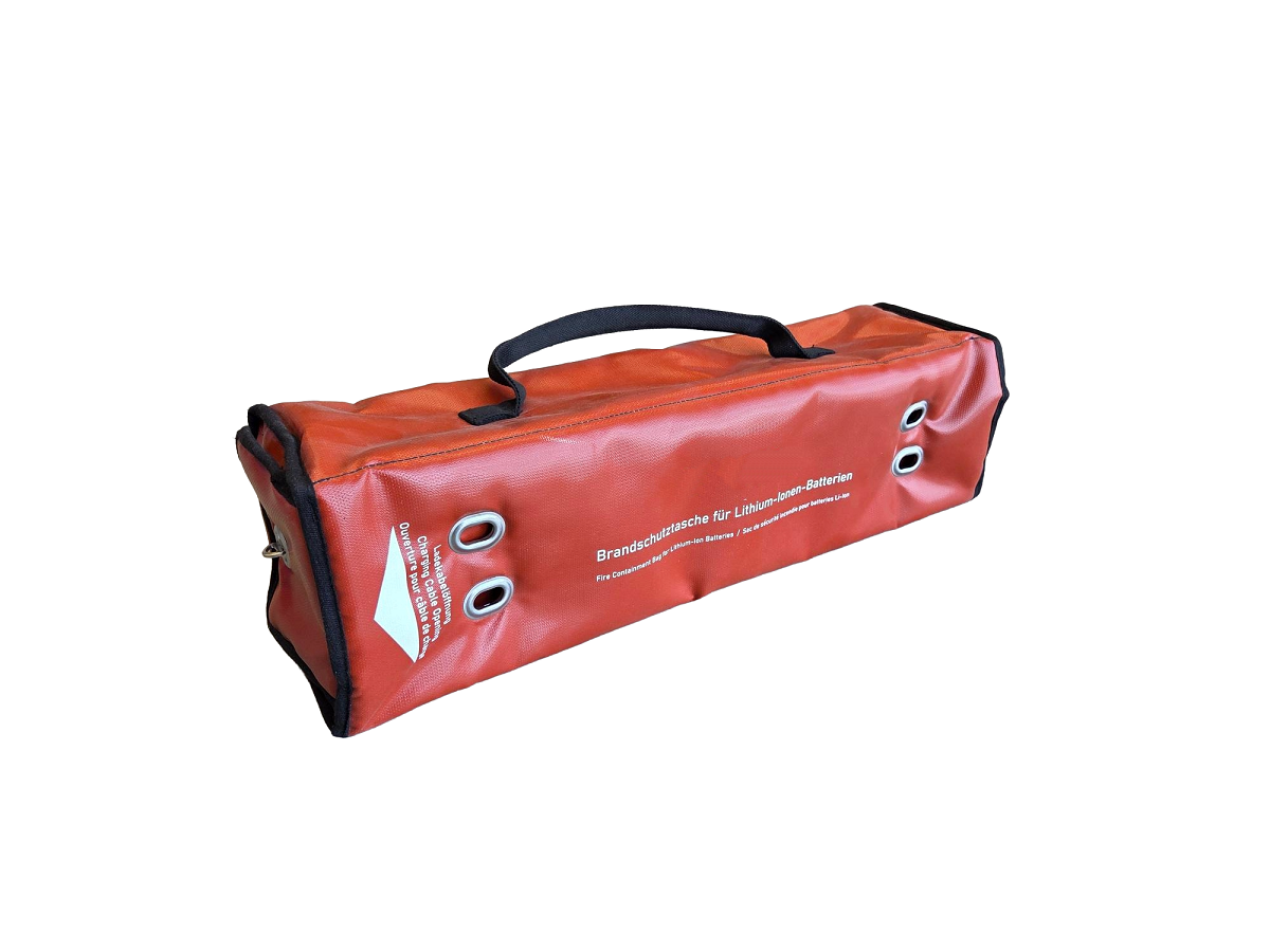 Funda de carga alargada naranja, ignífuga, de material robusto con asa negra. Cuatro ojales metálicos plateados en extremos y parte superior guían el cable de carga. Para cargar, guardar y transportar con seguridad baterías de litio.