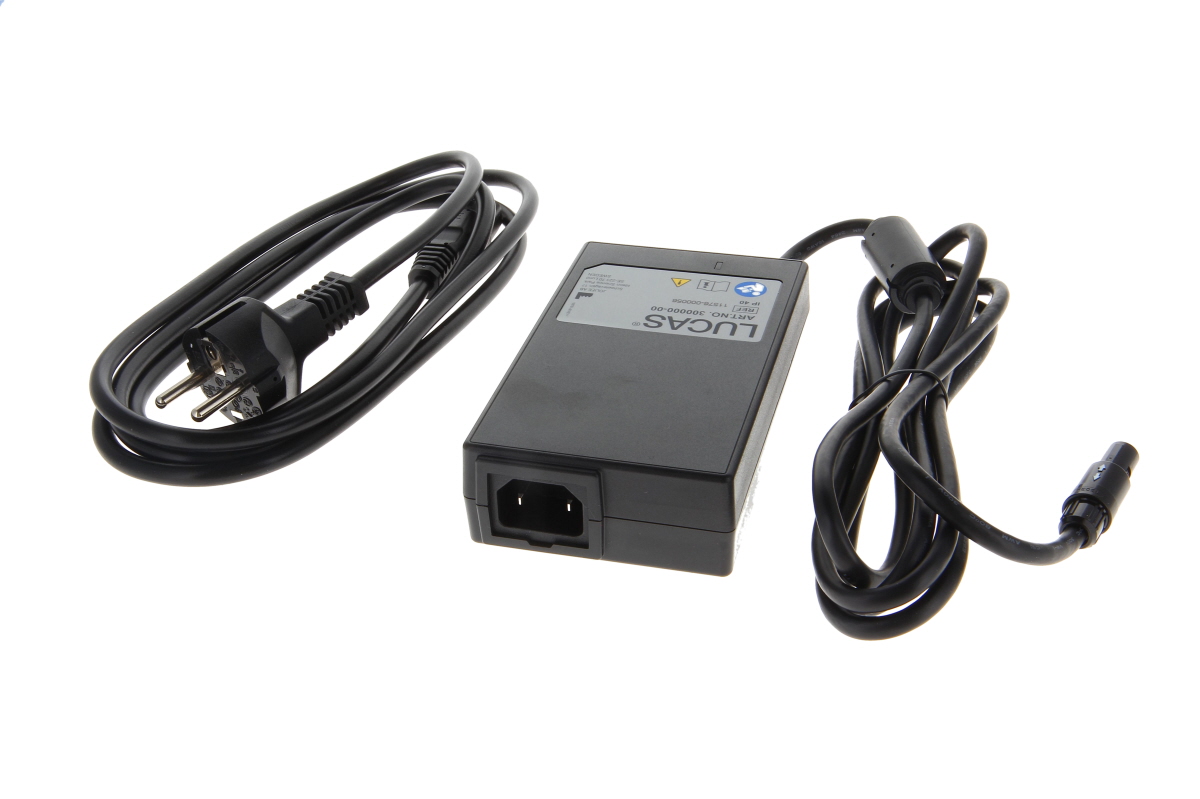 Black rectangular ‘Physio Control’ power supply unit for the Lucas 3 on a white background. Left: coiled power cable with Euro plug to the unit. Right: another cable with special round plug. The word ‘LUCAS’ is printed on it.
