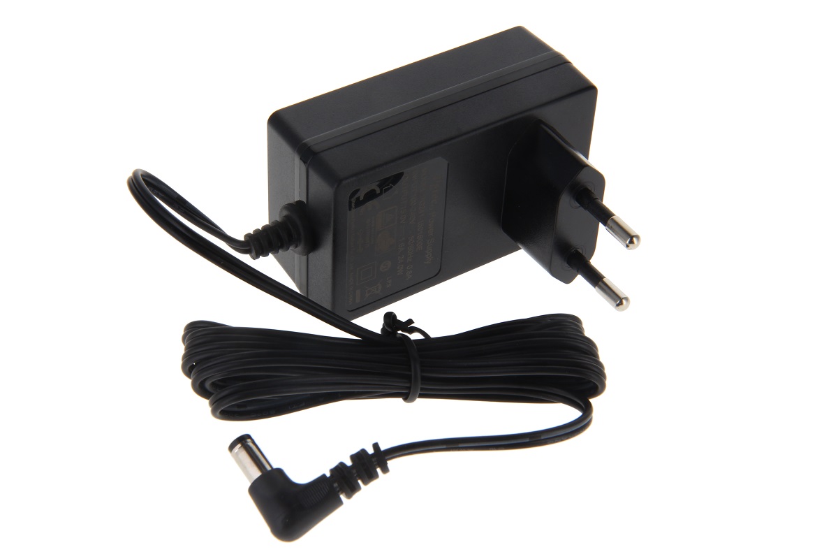 Cargador compacto y negro de CoPacks, con enchufe europeo de dos clavijas integrado. Cable largo y negro, enrollado de forma ordenada, que termina en un conector hueco acodado. Compatible con las radios Kenwood, TK2140 y TK2160.