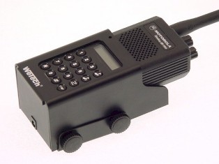 Radio Motorola GP300 negro en soporte de coche negro Wetech. Con pantalla, teclado y altavoz. Soporte con logotipo Wetech a la izquierda; abajo, dos tornillos moleteados negros para montaje. Carcasa metálica negra.