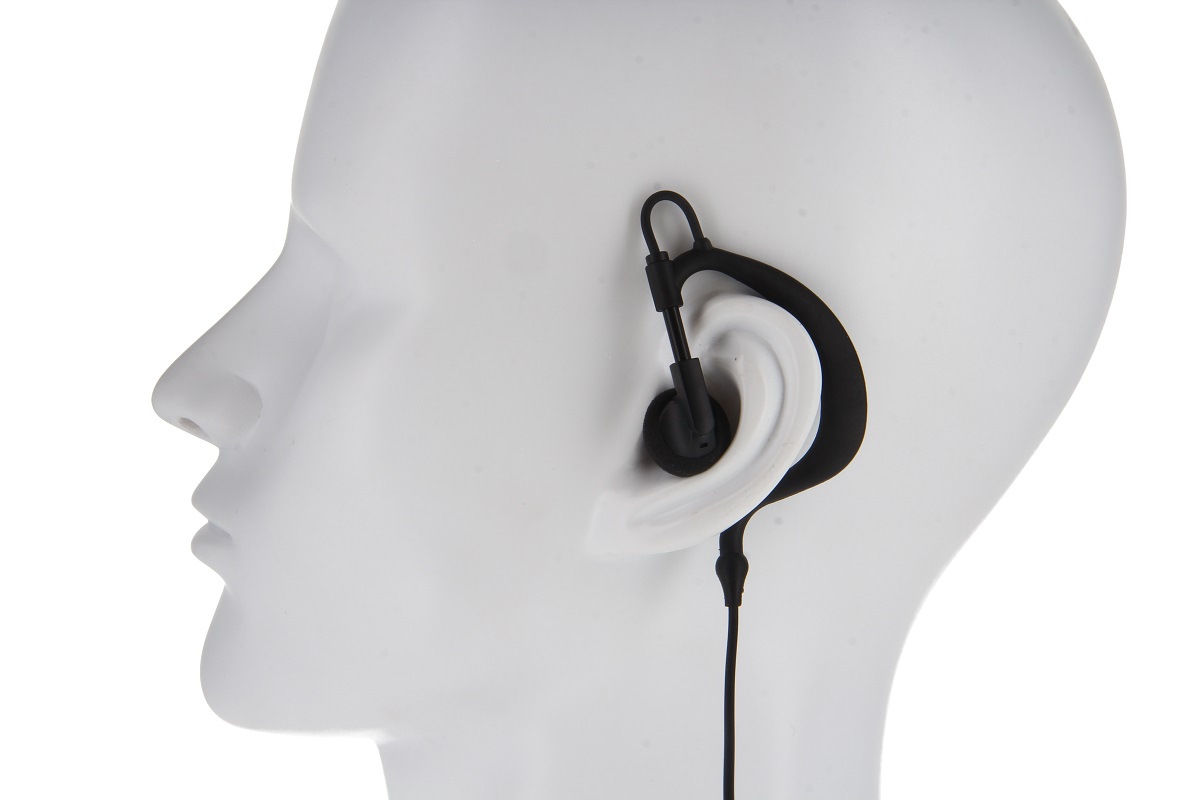 Auriculares negros con gancho y altavoz intraauricular colocados en la cabeza de un maniquí blanco. Un cable fino y negro en espiral desciende desde la oreja. Colocados con precisión en la oreja derecha y bien ajustados.