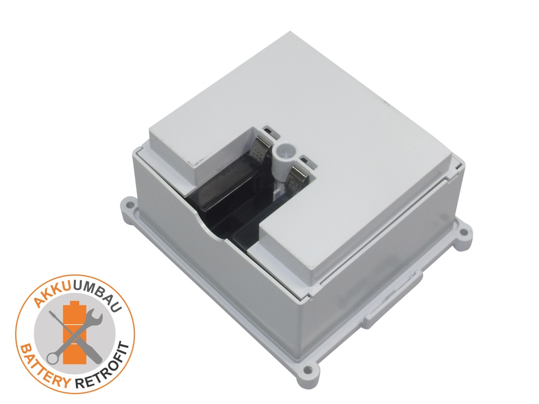 Grey rectangular housing for a lead-acid battery conversion kit, viewed at an angle from above. Top recess has black internal components and silver metal contacts for battery connection. With side mounting tabs, for a Wissner-Bosserhoff hospital bed.