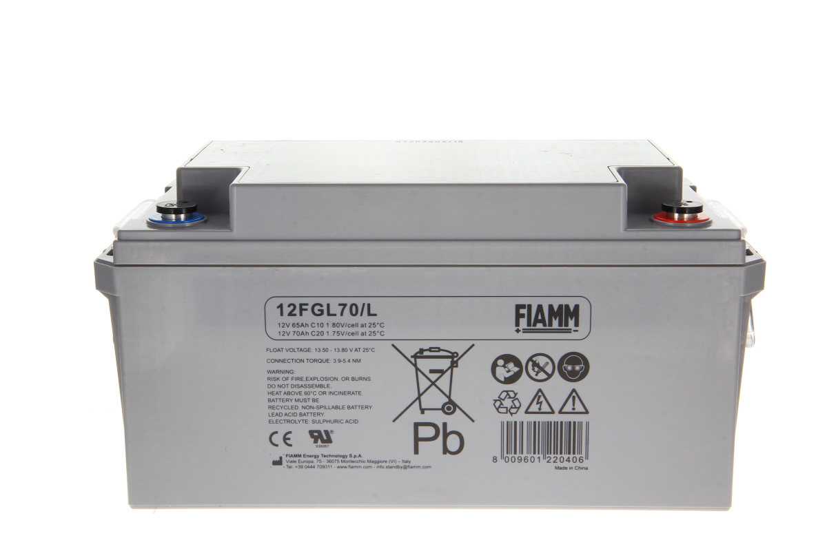 Batteria al piombo-acido FIAMM, grigia e rettangolare, modello 12FGL70/L su sfondo bianco. In alto, due terminali contrassegnati a colori (blu/rosso). Lato anteriore con dati (12V 65Ah), simboli di sicurezza e la sigla Pb.
