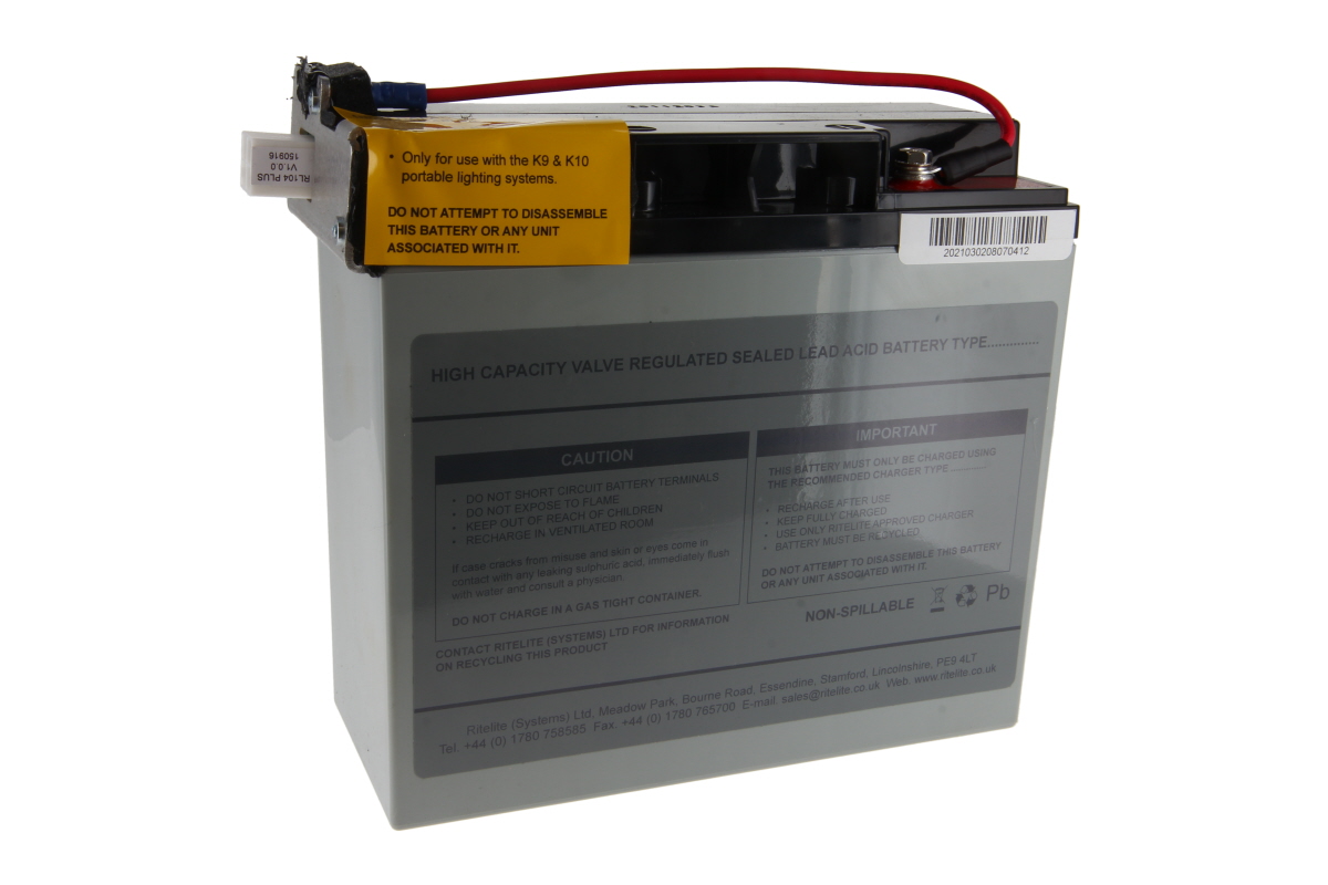 Grey rectangular lead-acid battery with a black top and visible terminals. Yellow warning label regarding use with portable lighting systems. Labels: VRLA sealed lead-acid, non-spillable, Pb. Genuine part Rosenbauer e RLS1000/2000, 12V 22Ah.