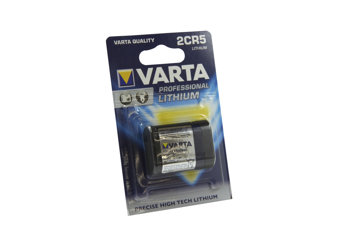 Eine schwarze Varta Lithium 2CR5 Batterie in originaler, schimmernder Blisterverpackung. Dunkelblaue Verpackung mit hellem Verlauf, Varta Logo und Aufschrift „PROFESSIONAL LITHIUM“ sowie „2CR5“, schräg vor weißem Hintergrund.
