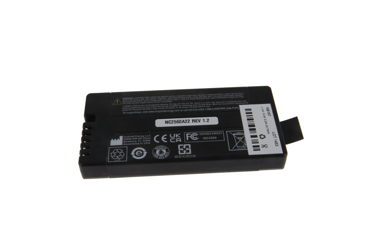 Svart rektangulärt litiumjonbatteri NC2560A22 (REV 1.2) på vit bakgrund. Flera anslutningsstift på smalsidan. Överst tillverkaruppgifter, varningar, återvinningssymboler och certifieringsloggor; streckkod delvis synlig.