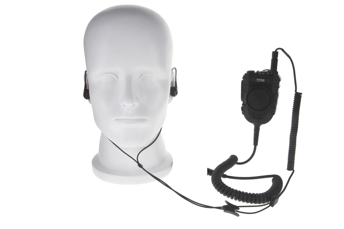 Microfono ad altoparlante nero MM50-TAC " TITAN " con pulsante PTT e griglia, collegato tramite cavo a spirale a cuffie intrauricolari abbinate. Cuffie su testa manichino bianca, auricolari in entrambe le orecchie. Per Motorola MXP600/R7.