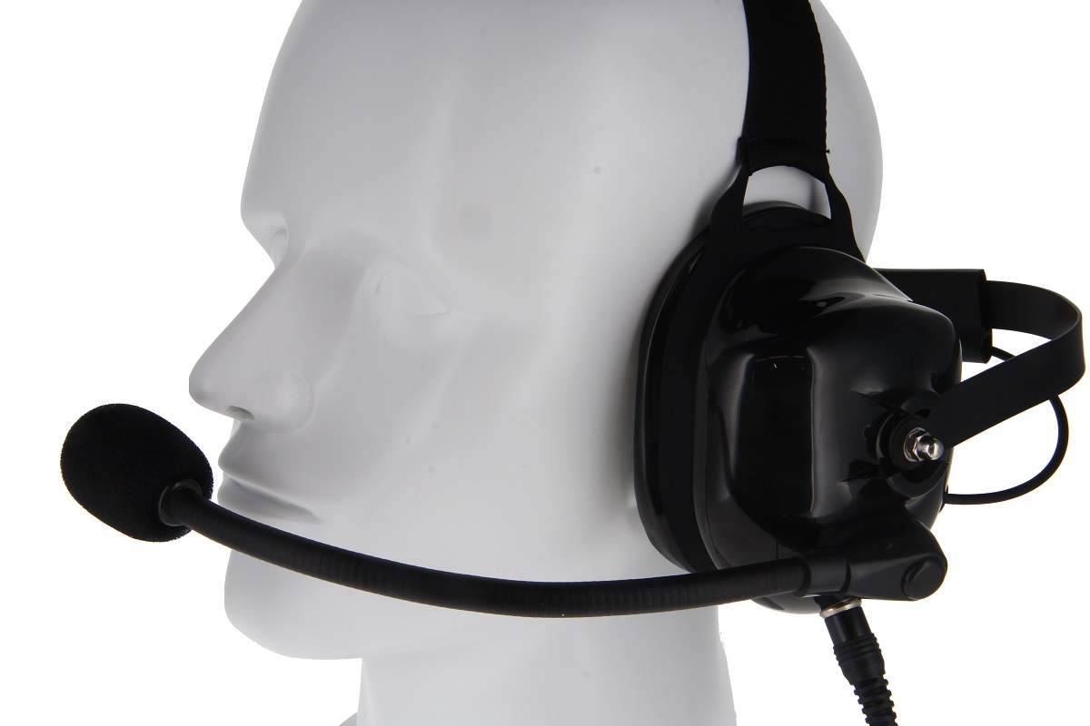 Svart CoPacks headset GES-H05 på vit skyltdockas huvud, i sidled. Pilotheadsetet omsluter höger öra med en stor öronkåpa och har en flexibel mikrofon med skumskydd framför munnen. Kabeln leder nedåt.