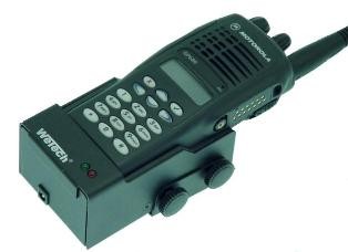 Radio portátil Motorola oscuro (serie GP) en soporte de coche Wetech negro con logotipo y pantalla LED. Botones laterales giratorios para fijación. Con teclado, pantalla y antena; carga inferior.