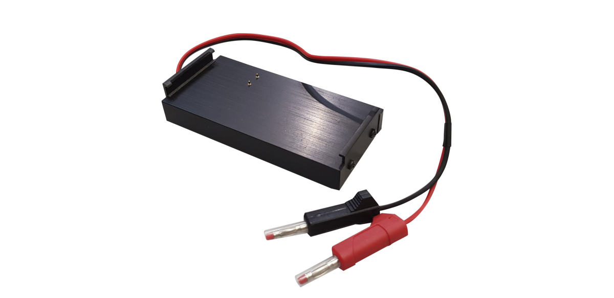 Soporte de carga de batería rectangular de color negro con dos pines de contacto dorados. Par de cables rojo y negro con dos conectores de seguridad de 4 mm para cargar las radios de Motorola GP320/340/360/380. Conectores rojo y negro.