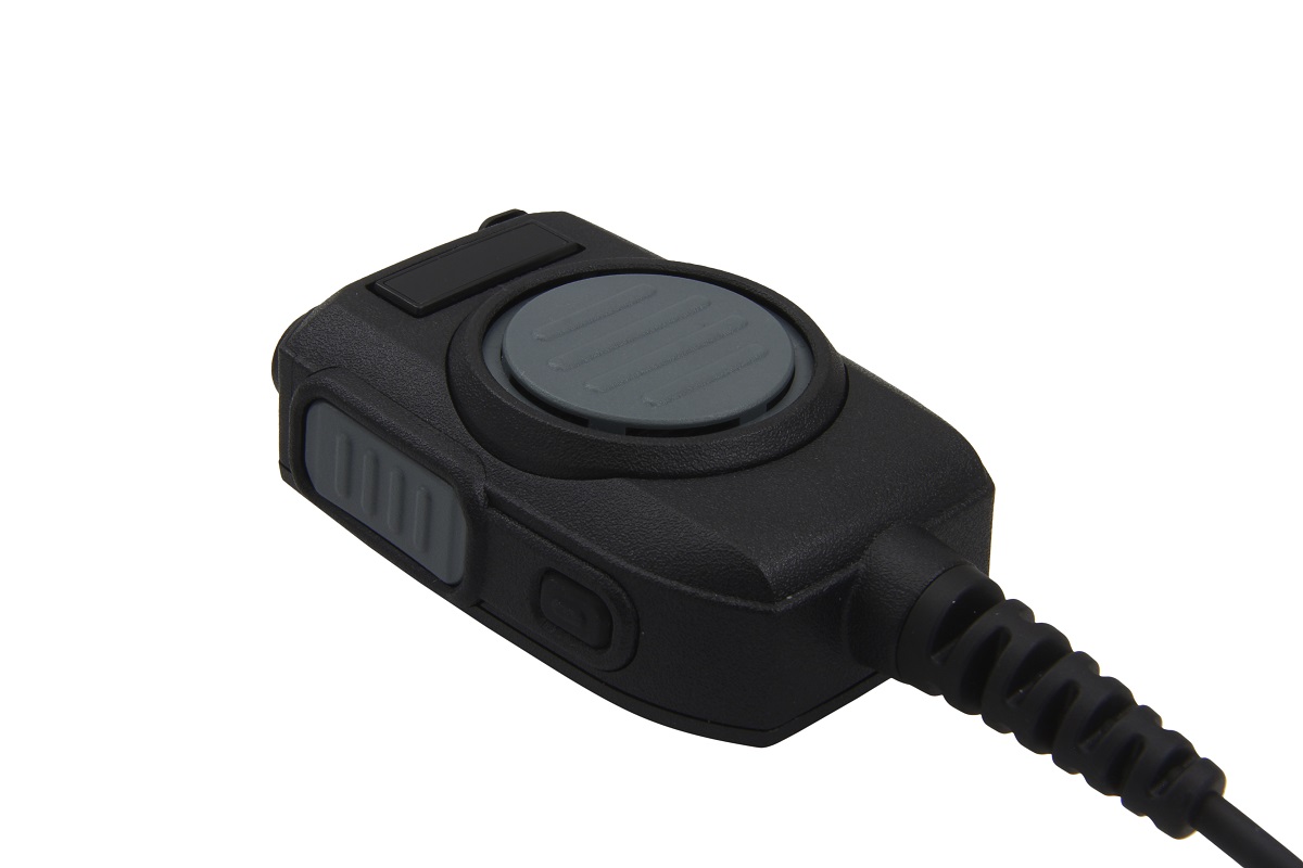 Microfono con altoparlante GE-XM05 nero " CoPacks" con finitura opaca, posizionato di traverso su uno sfondo bianco. In alto, un grande pulsante di comando rotondo grigio (PTT). Sul lato, un pulsante grigio allungato e zigrinato. Cavo a spirale.