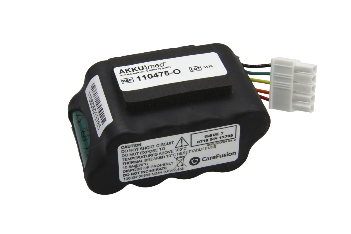 Batería recargable NiMH negra con etiqueta blanca: «AKKUmed REF 110475-O», «LOT 5139». Conector blanco de 4 polos con cables de colores. Impreso: instrucciones de seguridad, «NiMH 9,6 V/2,4 Ah», modelo «1000SP00605» (Alaris Gateway Workstation).