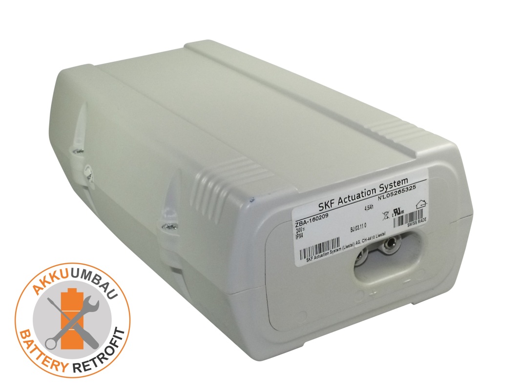 Grey, rectangular battery compartment with slightly rounded edges. Labelled: ‘SKF Actuation System’, 24V, 4.5Ah. Two round, silver terminals visible on the right. Battery conversion for the Reha&Medi Mobilizer Medior.