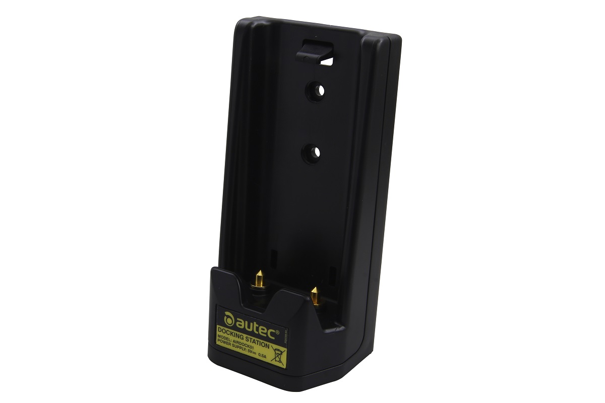Schwarze Autec Dockingstation mit zwei goldfarbenen Ladekontakten an der Unterseite. Auf dem gelben Etikett steht 'DOCKING STATION' und 'POWER SUPPLY: 5V 0.5A'. Es dient als Ladegerät für einen Akku und ist für die Wandmontage vorbereitet.